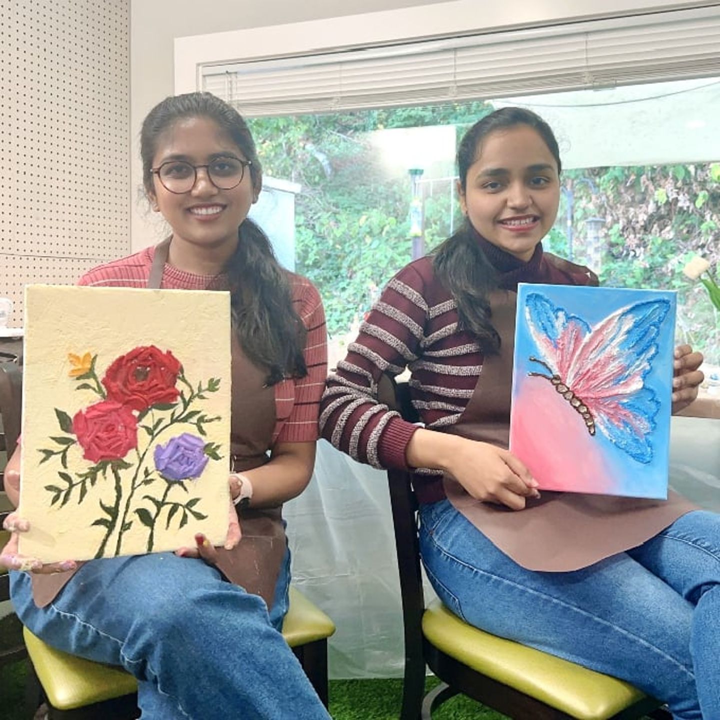 Two people holding artwork