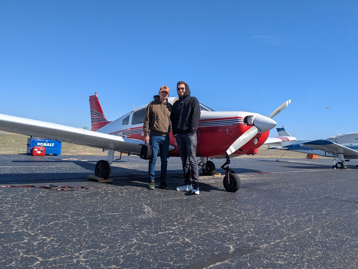 Two people in front of plane