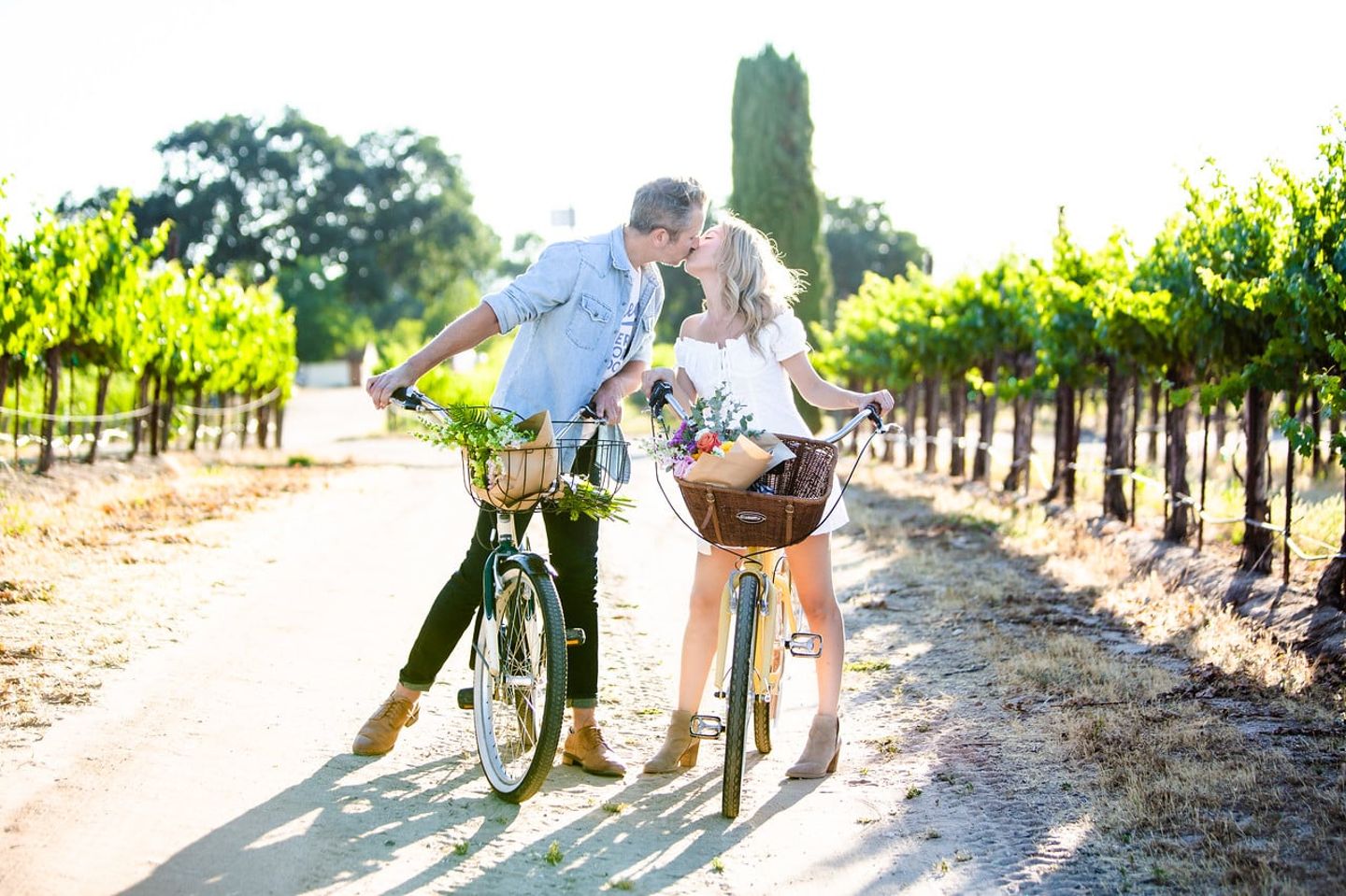 Couple riding bikes in vineyard