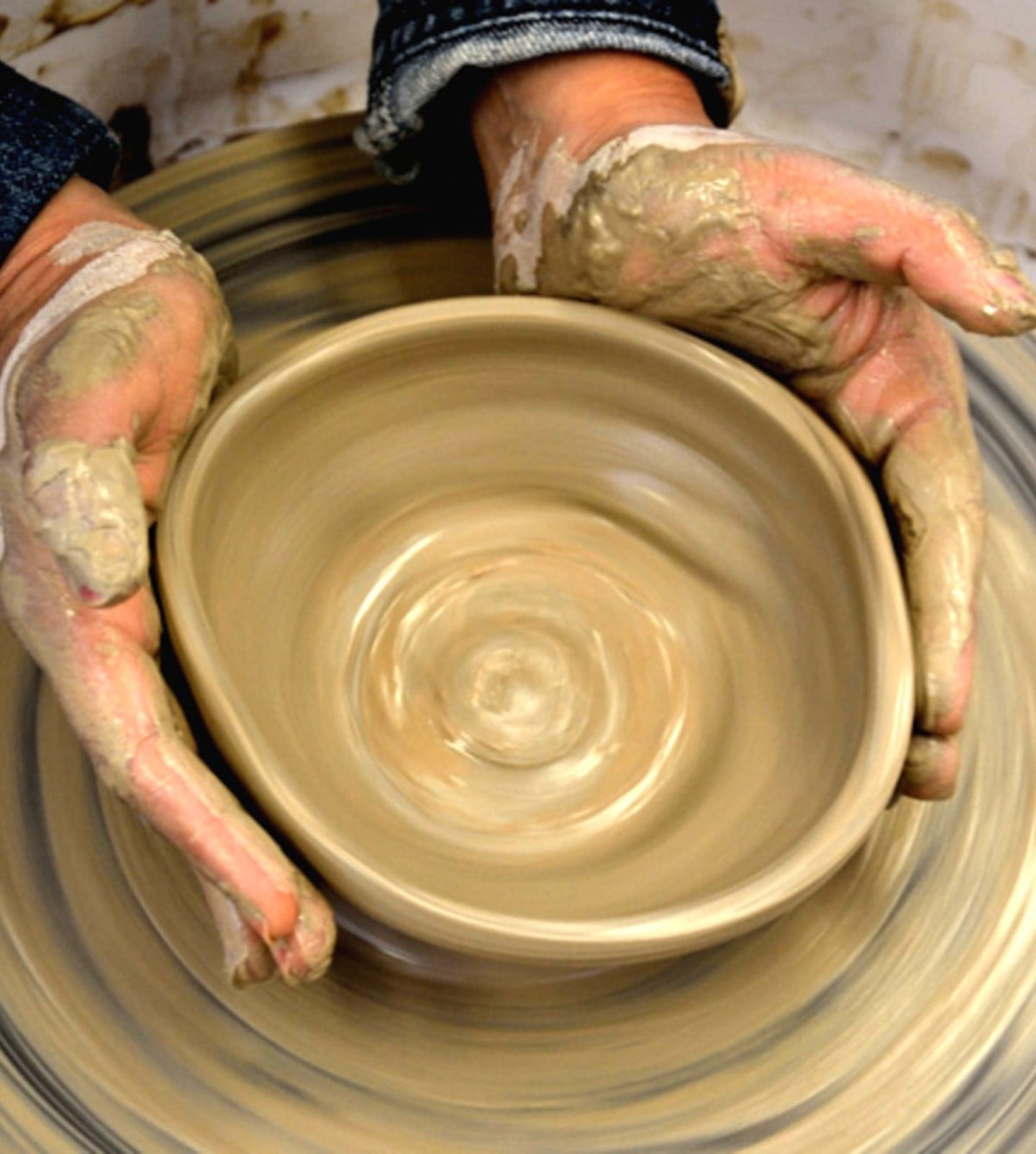 Person spinning clay bowl