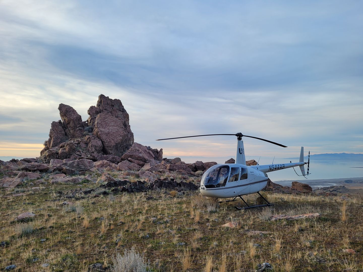 Helicopter on ground near rock