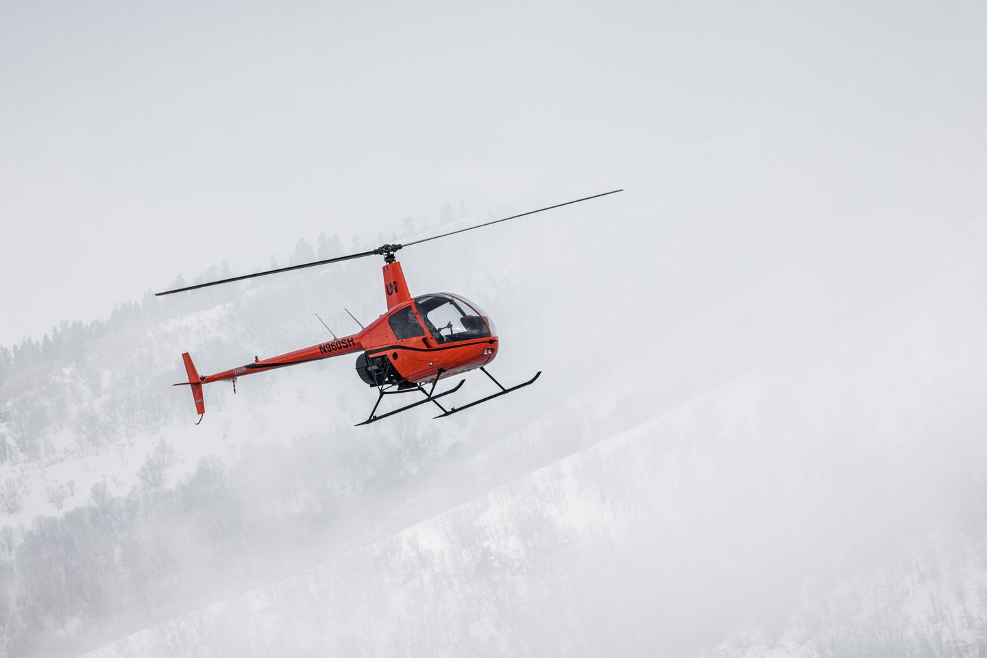 Helicopter flying near mountain
