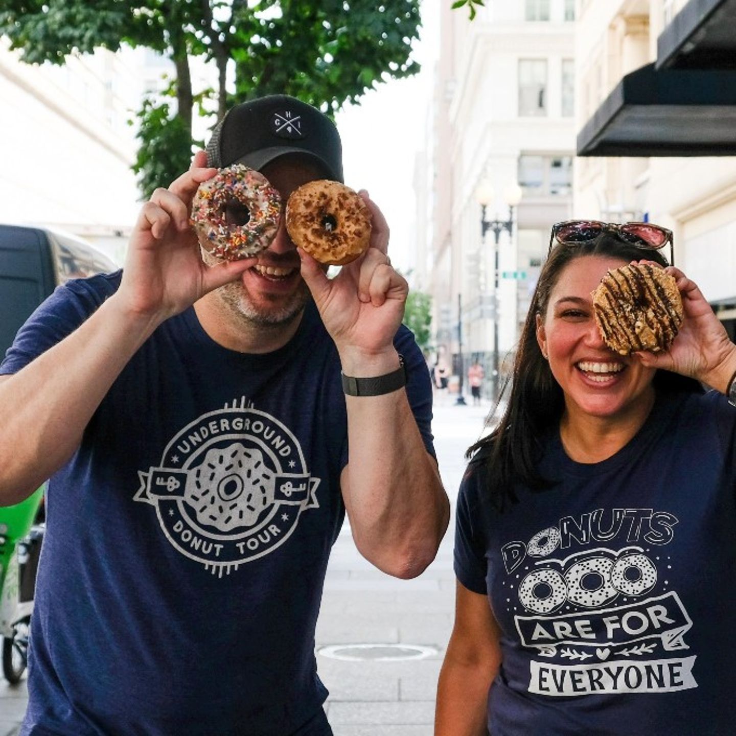 Two People Holding up Donuts