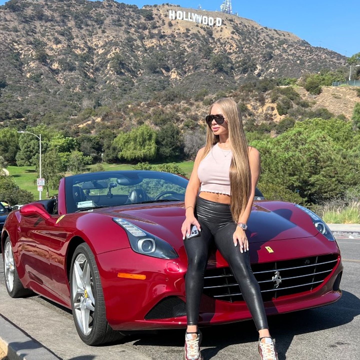 Woman with Ferrari in front of Hollywood sign