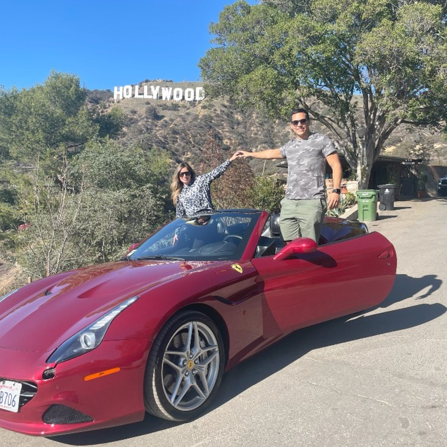 Man in front of Hollywood sign in Ferrari