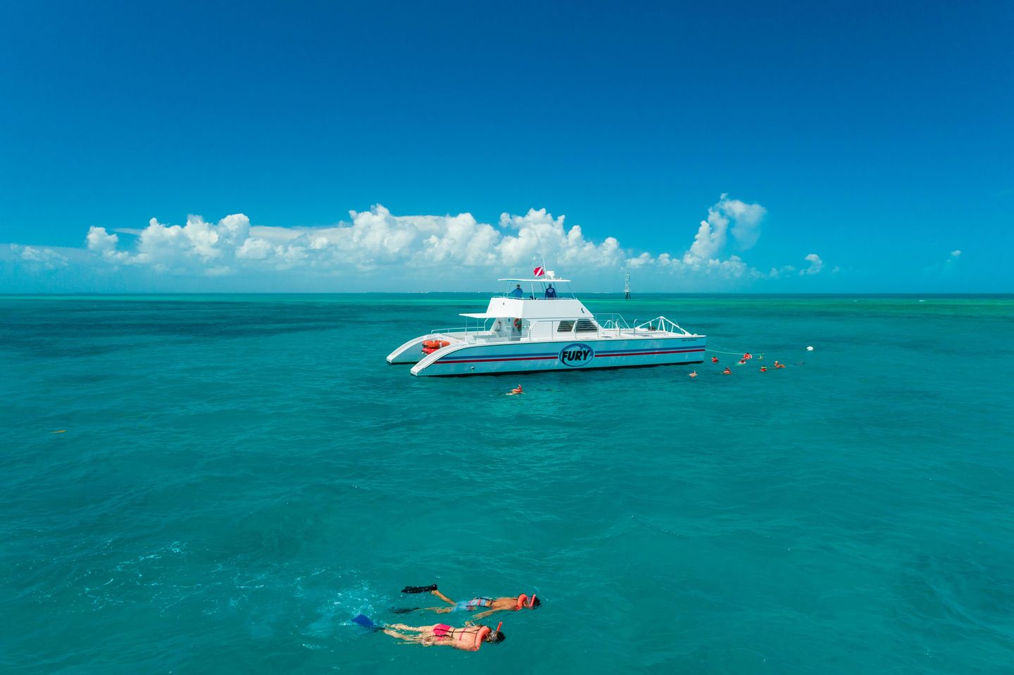Couple snorkeling near boat