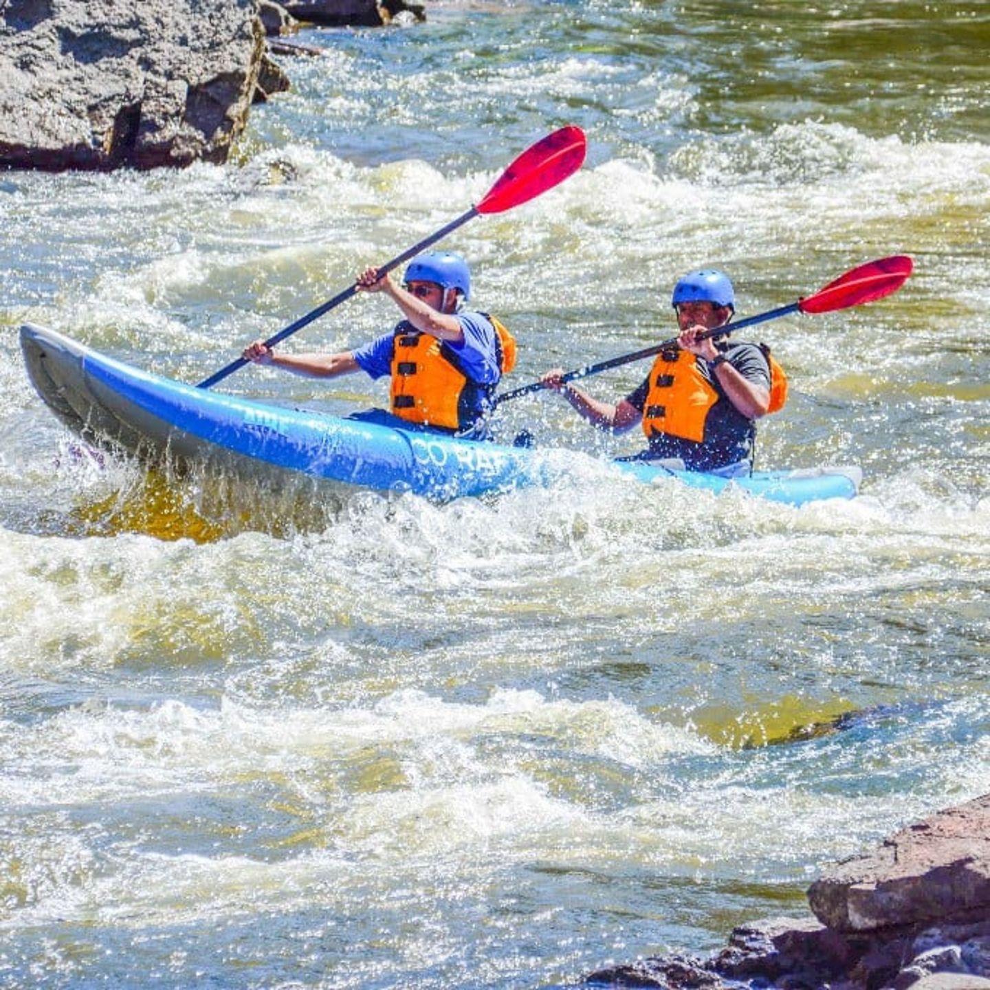 Two people kayaking in rapid