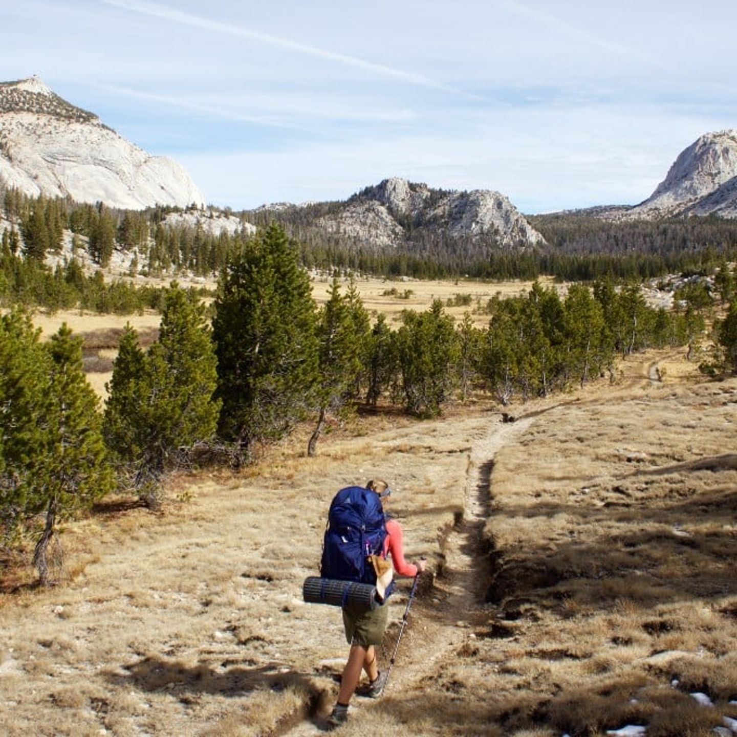 Person hiking on trail through mountains