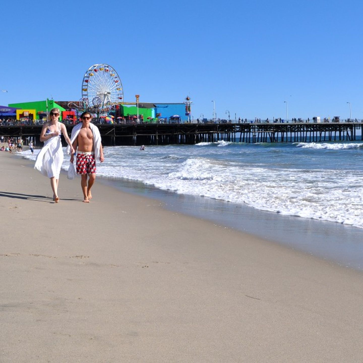Two people walking on beach