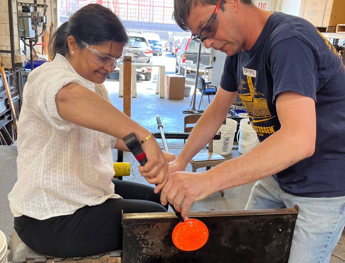 Two people molding glass