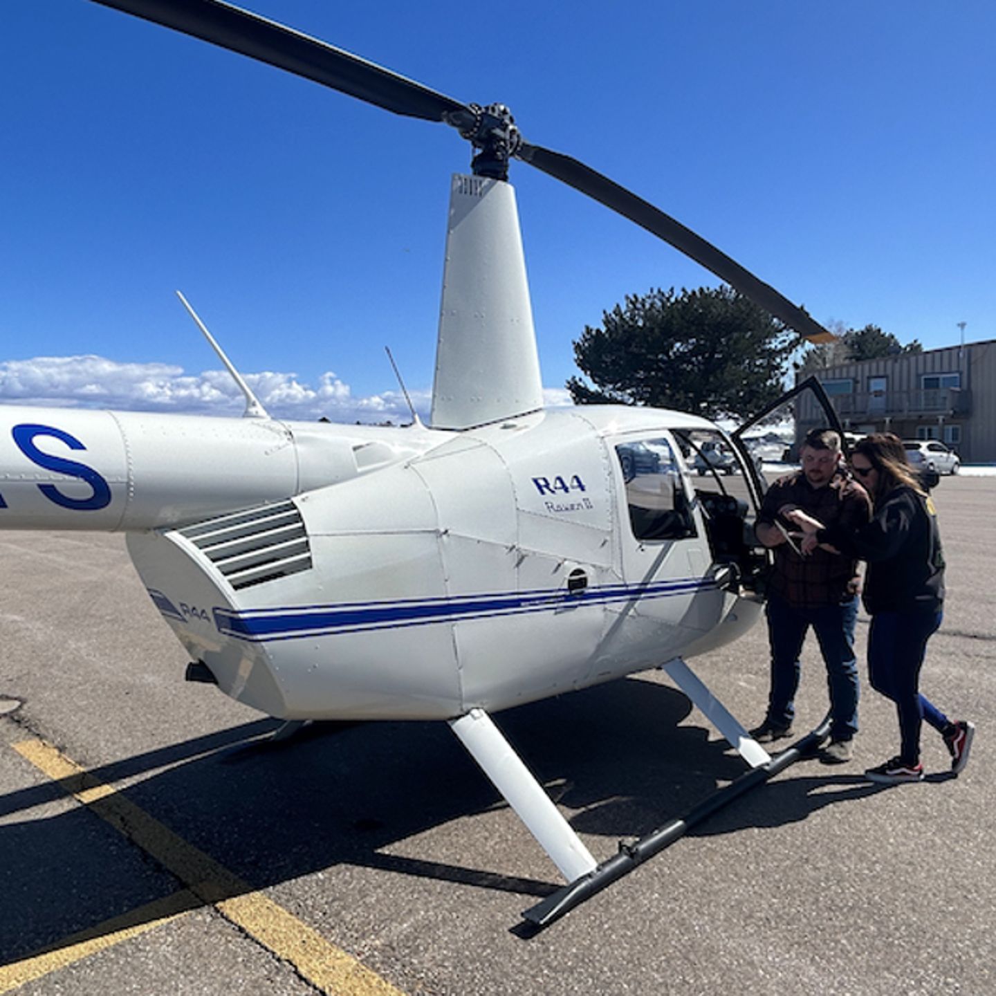 Two people next to helicopter