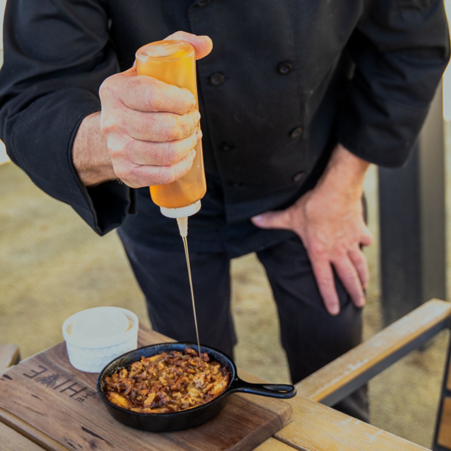 Person pouring honey on dish