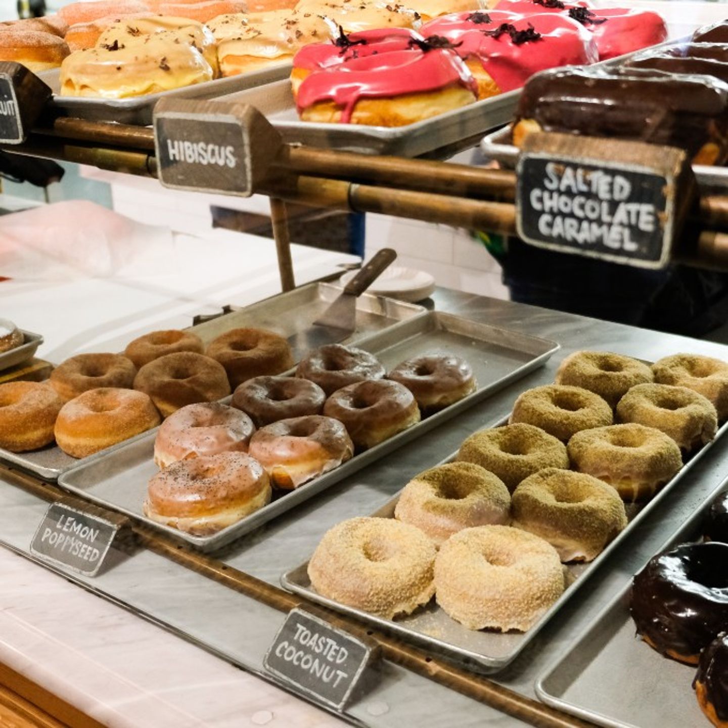 Donuts in Display Case with Signs