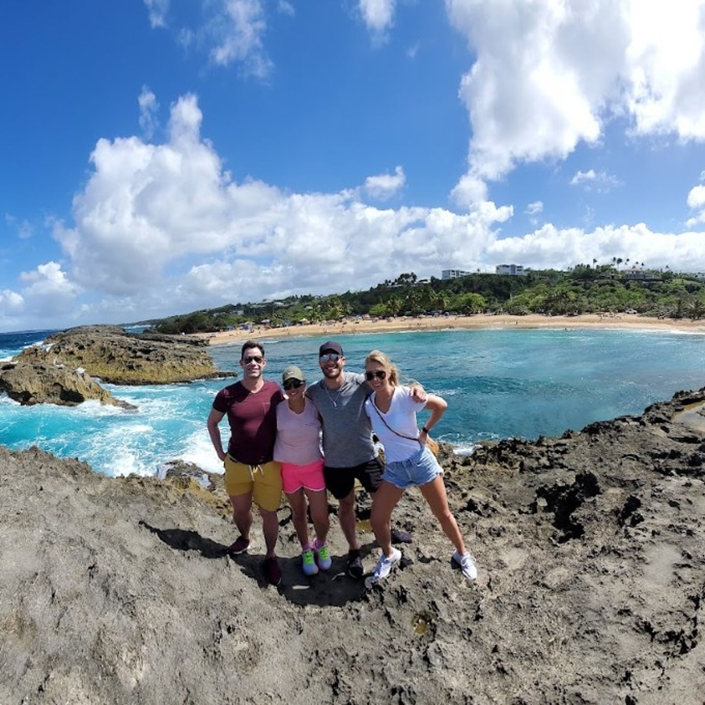 Group Posing on Rock with Ocean Background