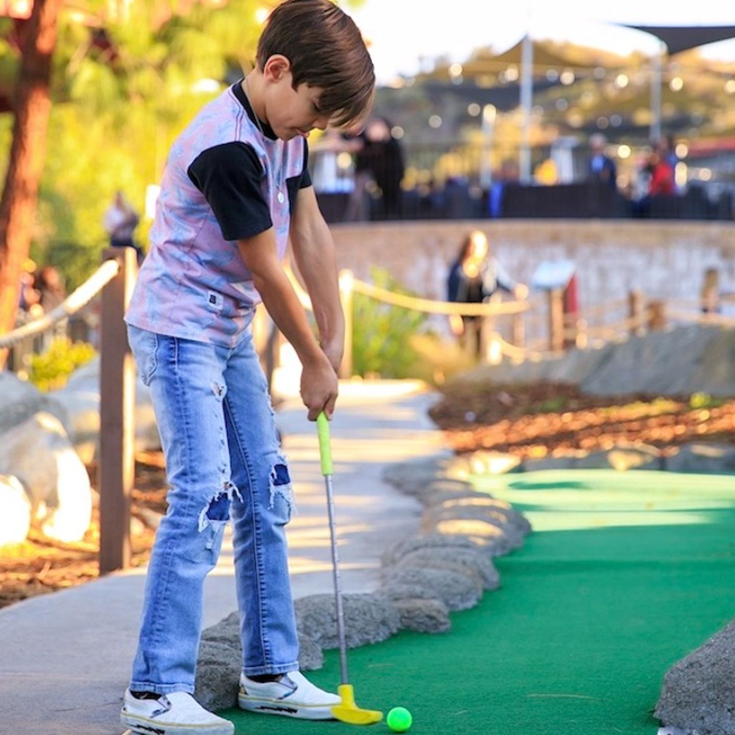 Kid playing mini golf