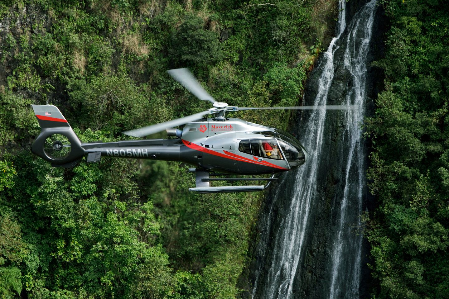 Helicopter next to waterfall