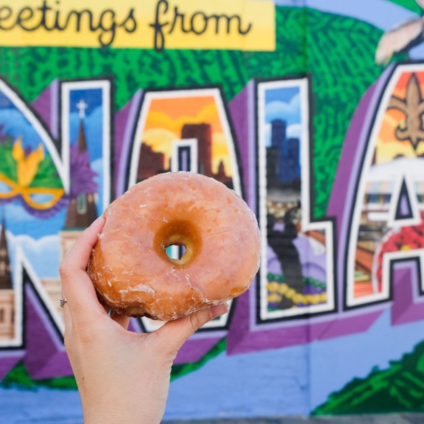 Donut Being Held Up in Front of 