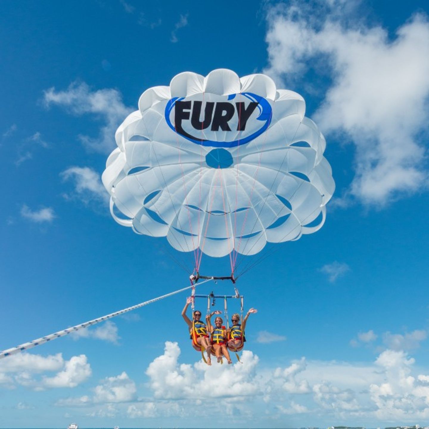 Three people parasailing