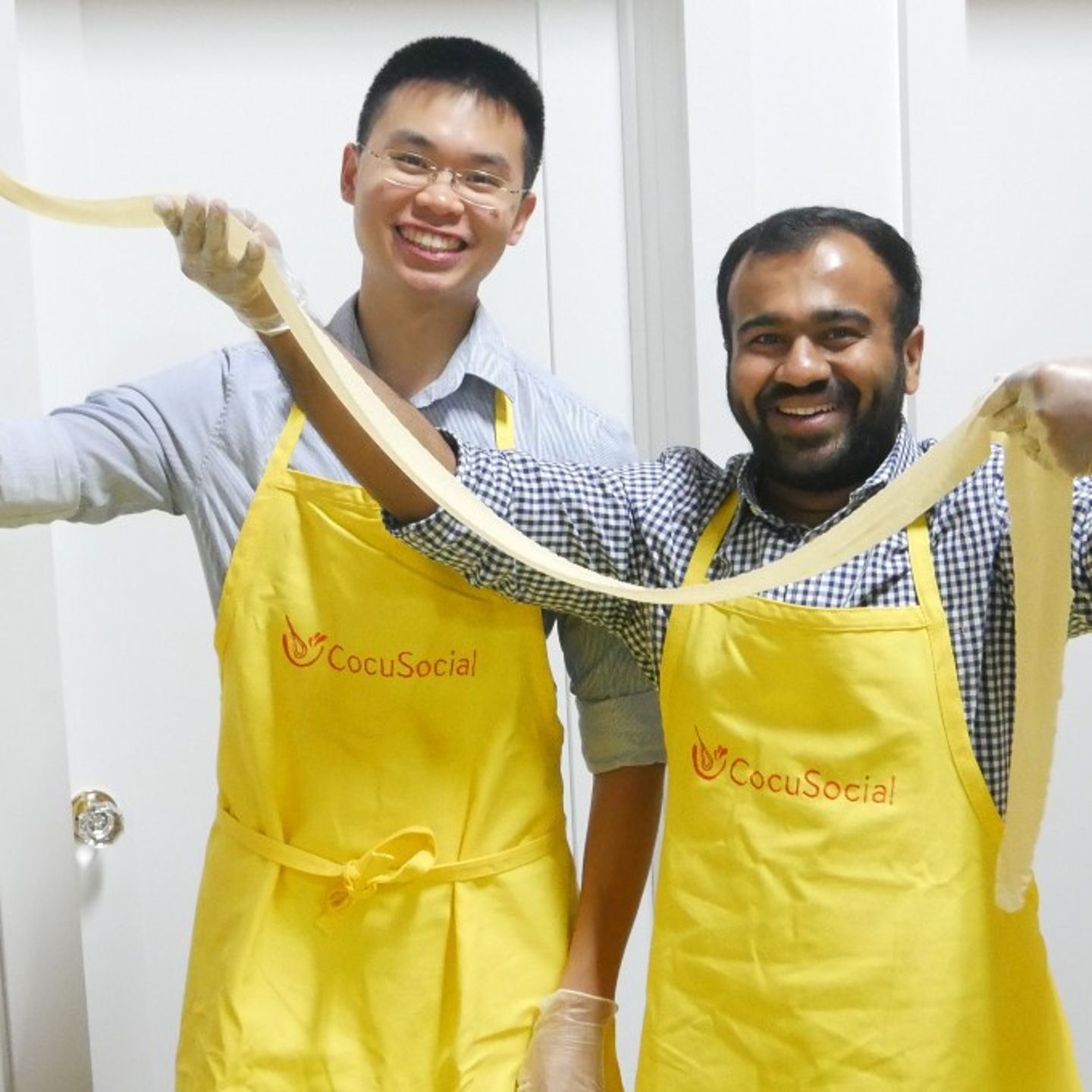 Two people holding pasta