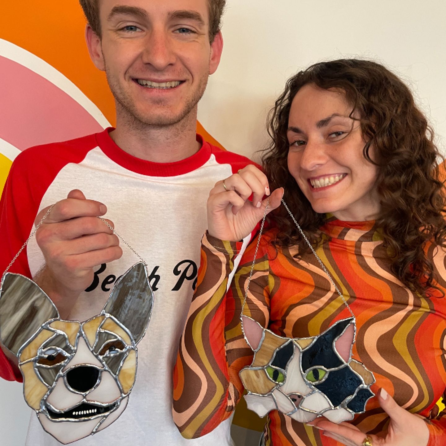 Two people holding stained glass pets
