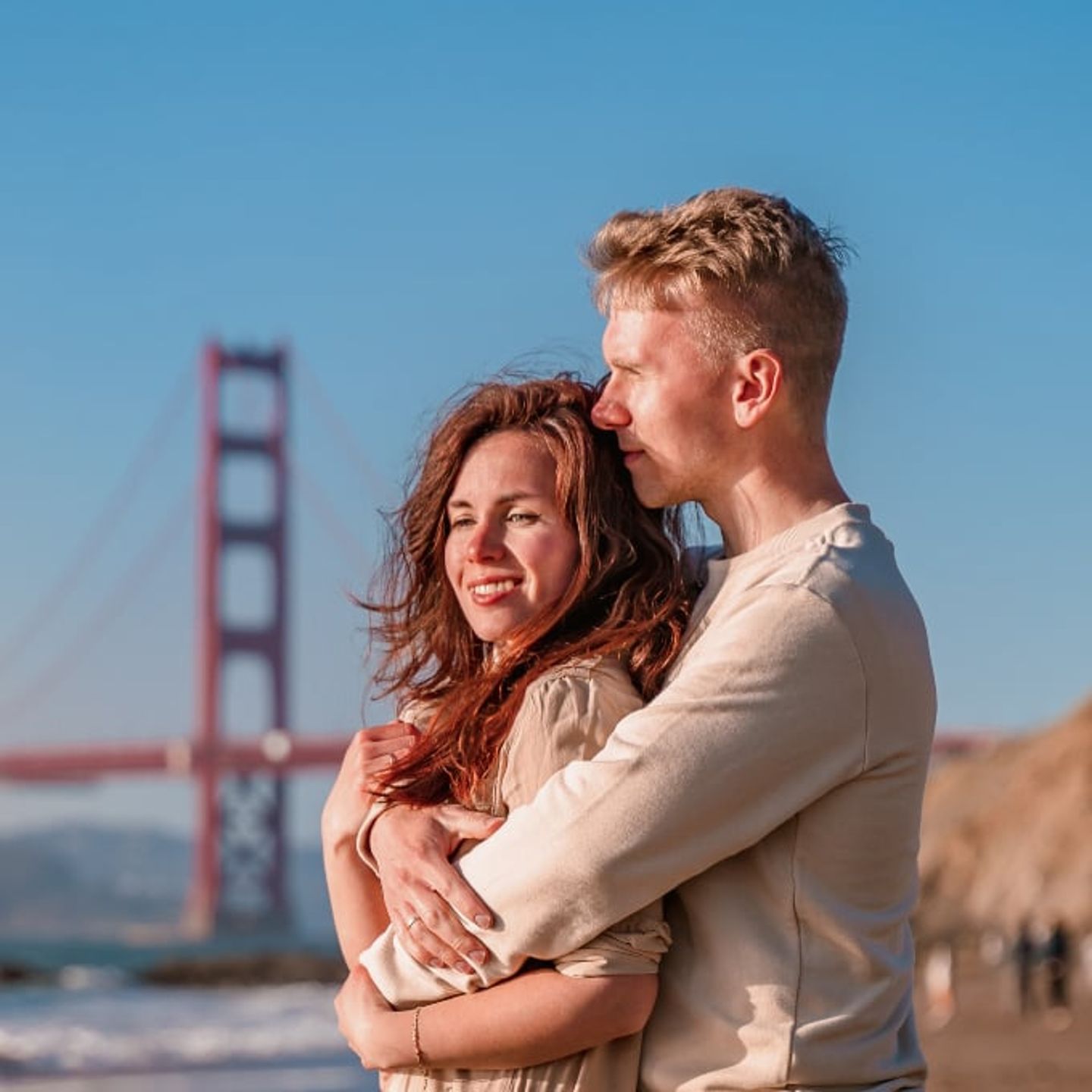Couple on beach near bridge