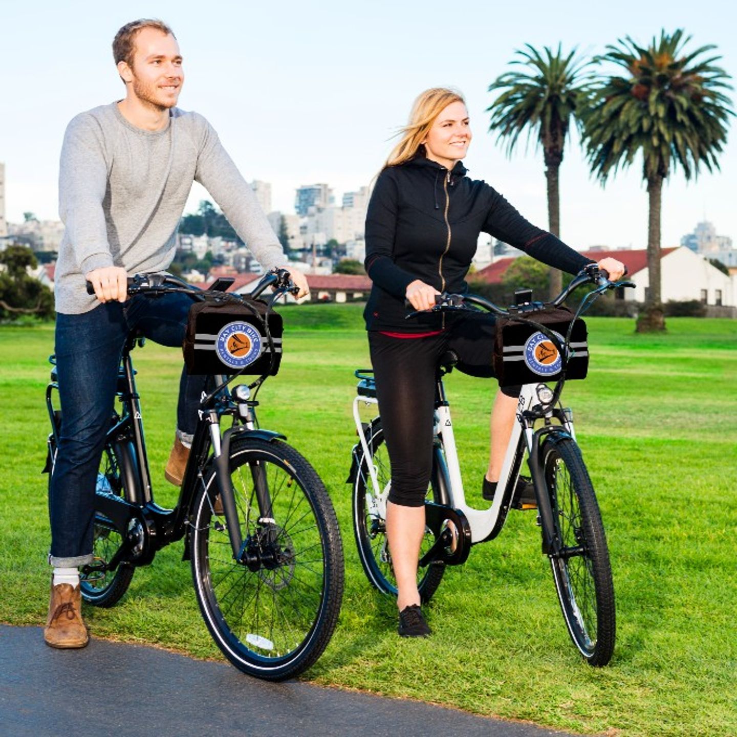 Two people riding bikes in park