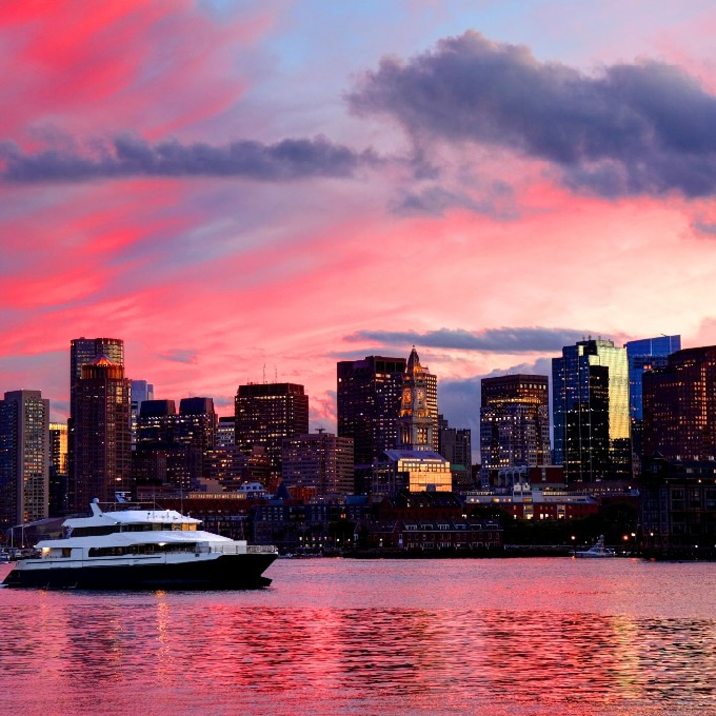 Boat sailing near city at sunset