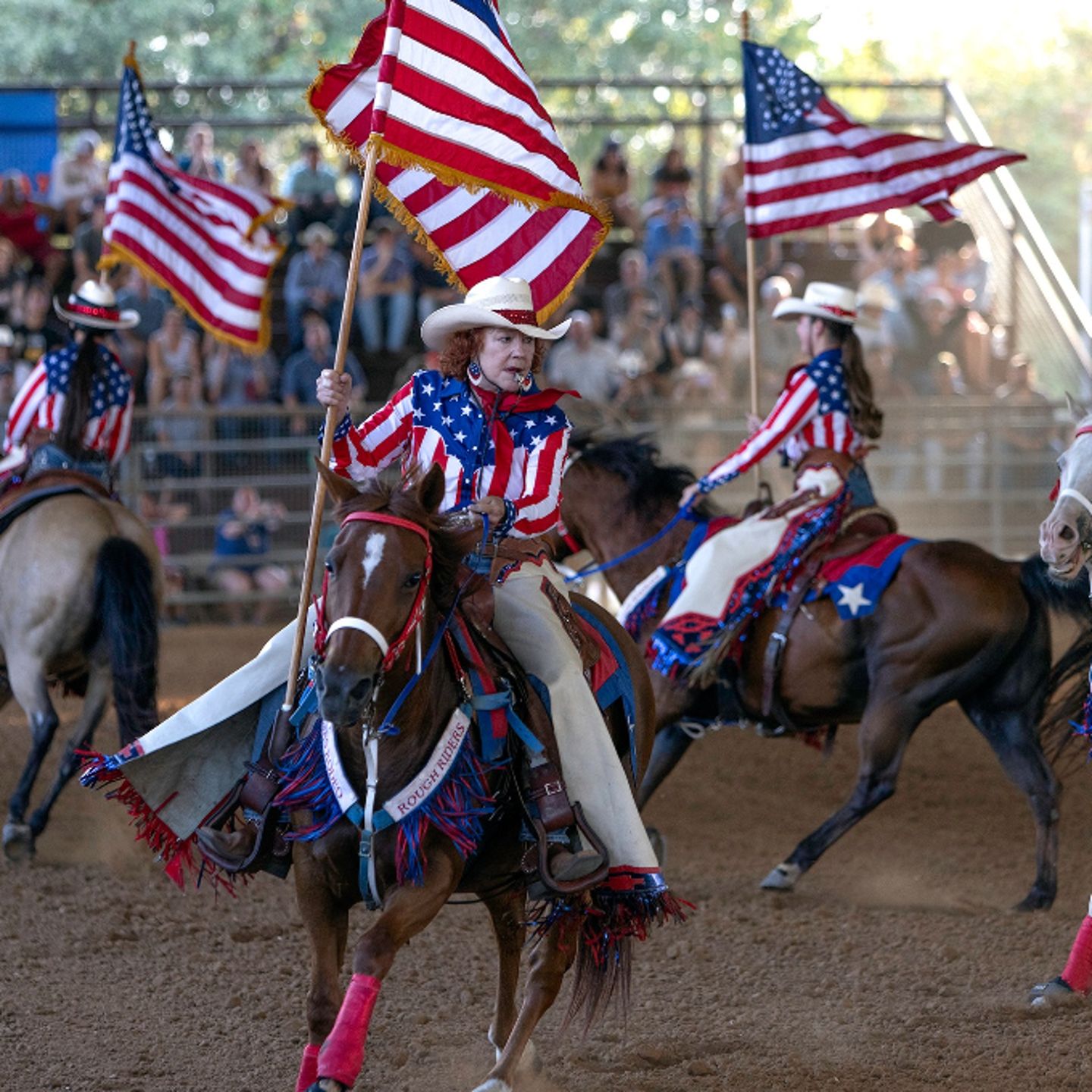 People riding horses with flags